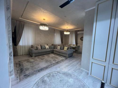 uma sala de estar com um sofá e uma mesa em lux apartment in tashkent city em Tashkent