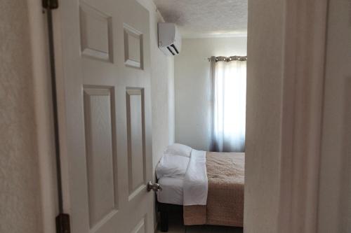 a white door leading to a bedroom with a bed at Marina Diamante Planta Baja in Acapulco