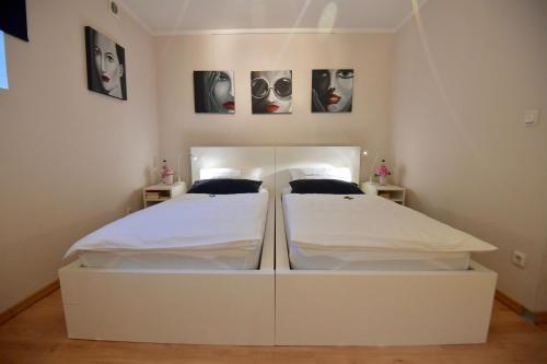 a white bedroom with two beds in it at Gästehaus Scholly in Saarlouis