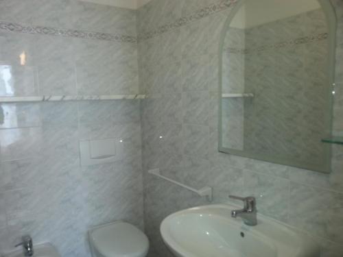 a bathroom with a sink and a toilet and a mirror at Hotel Marylise in Rimini
