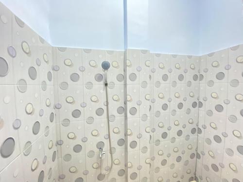 a shower in a bathroom with a shower curtain at Kanaan Guesthouse RedPartner in Manado