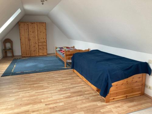 a bedroom with a bed and a wooden floor at Ferienwohnung im Nierott in Gettorf