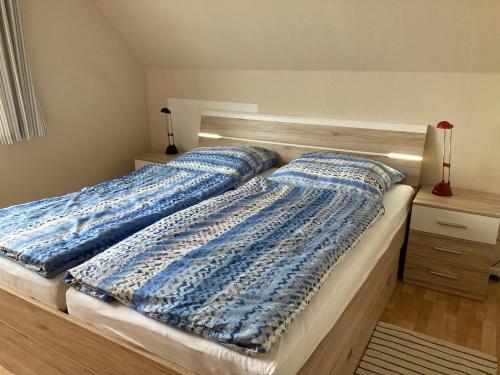 a bed with two blue pillows on top of it at Ferienwohnung im Nierott in Gettorf
