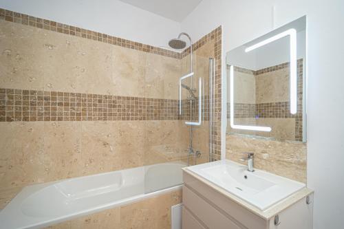 a bathroom with a tub and a sink and a mirror at Old town luxury in new building. in Cluj-Napoca