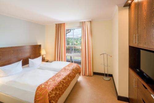 a hotel room with a bed and a large window at Castello Apartments in Lüneburg