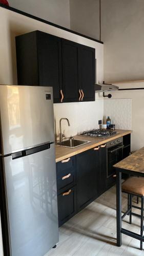 a kitchen with a refrigerator and a sink and a table at Palazzo Liberty in Monreale