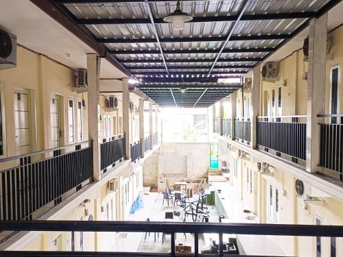 an empty hallway of a building with tables and chairs at RedDoorz @ Al Muhajir Homestay Kendari in Kendari