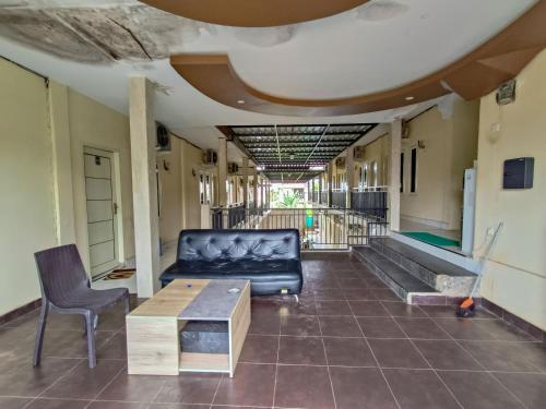 a living room with a couch and a table at RedDoorz @ Al Muhajir Homestay Kendari in Kendari
