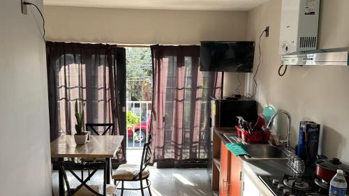 a kitchen with a sink and a table in front of a window at SaVilie 1 - Seguridad y Comfort in Guadalajara