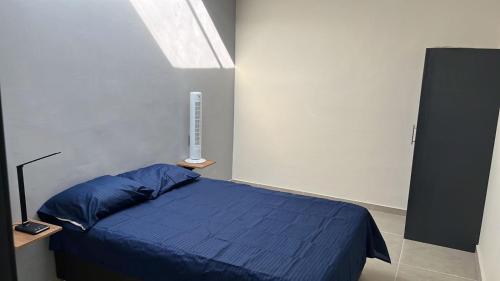 a bedroom with a bed with blue sheets and a window at SaVilie 1 - Seguridad y Comfort in Guadalajara