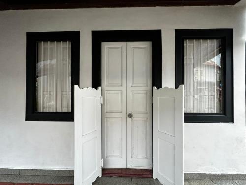 uma casa branca com duas janelas e uma porta branca em Check-Inn at Little India em Singapura