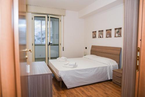 1 dormitorio con cama blanca y ventana en AF Apartments, en Vibo Valentia Marina