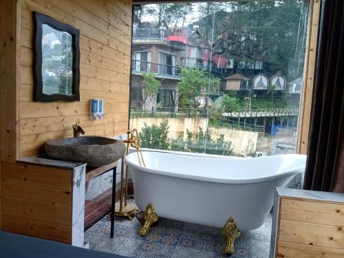 a bathroom with a tub and a sink and a window at Mimosa Villa in Vĩnh Phúc