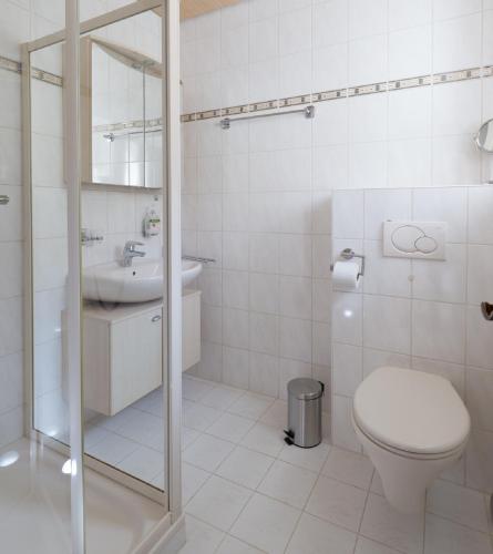 a white bathroom with a toilet and a sink at Ferienwohnung „Prims“ in Wadern