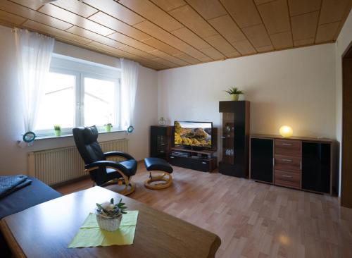ein Wohnzimmer mit einem Tisch und einem TV in der Unterkunft Ferienwohnung „Prims“ in Wadern