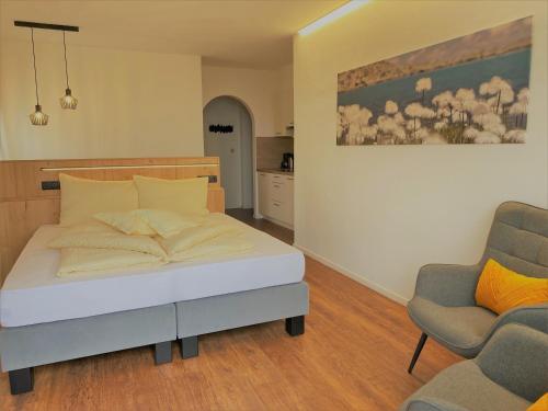 a bedroom with a bed and two chairs in it at Garni Winklerhof in Lagundo