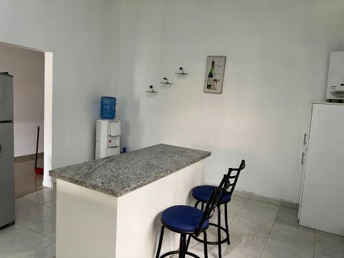 a kitchen with two blue stools at a counter at Villa Piña Alojamiento rural in San Rafael