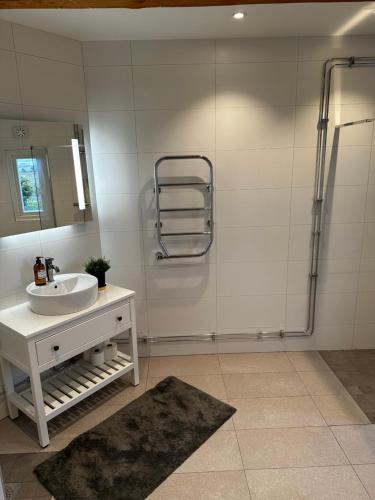 a white bathroom with a sink and a shower at Quadambra Park in Gärsnäs