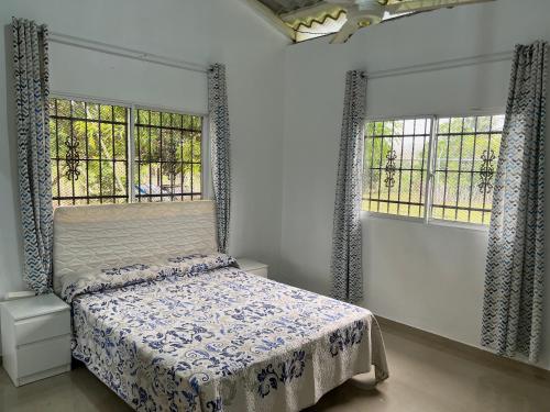 1 dormitorio con 1 cama y 2 ventanas en Villa Piña Alojamiento rural, 