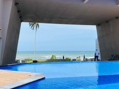 a large swimming pool with a view of the ocean at Hasara Oceanfront Apartments in Galle