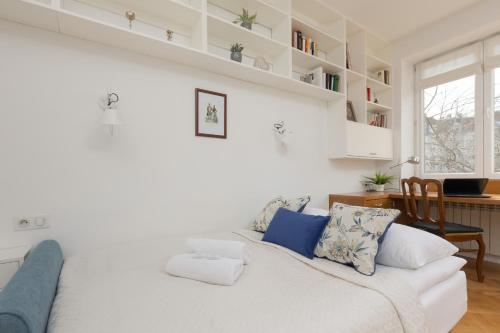 a white living room with a white couch and a desk at Koszykowa Sunny Studio by Renters in Warsaw