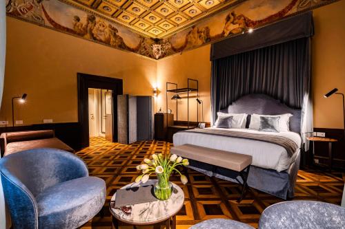 um quarto de hotel com uma cama, um sofá e cadeiras em Palazzo Keller em Veneza