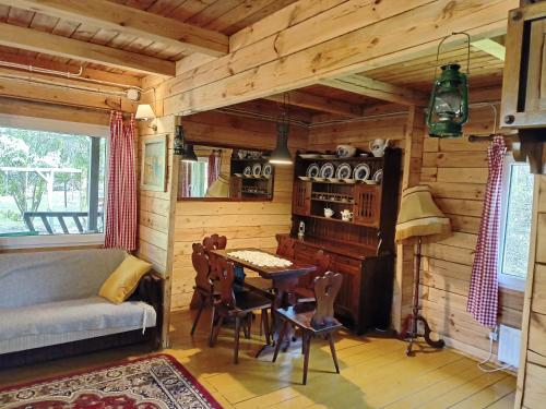 una sala de estar con una mesa en una cabaña de madera en Leśniczówka, en Olszewnica Stara