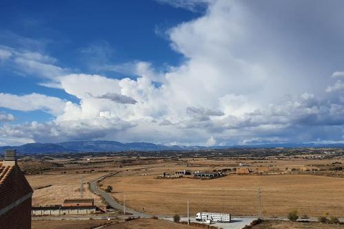 a view of a field with mountains in the distance at Cal Curpets - Bicicletas FREE in Puigvert de Agramunt