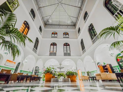 a large room with tables and chairs and palm trees at Senator Cádiz in Cádiz