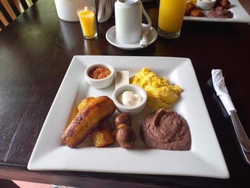 Un plato de desayuno con salchichas, patatas y huevos. en HOTEL EL VIAJERO, en La Libertad