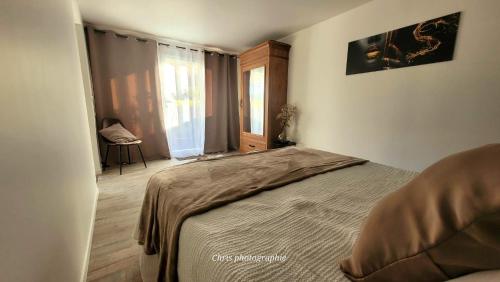 a bedroom with a bed and a window and a chair at Entre Ciel et Verdon in Castellane
