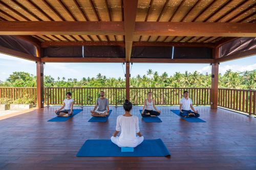 a group of people sitting in a yoga class at Adiwana Unagi Suites in Ubud