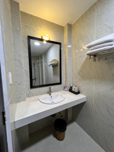 uma casa de banho com um lavatório e um espelho em May Studio em Da Lat