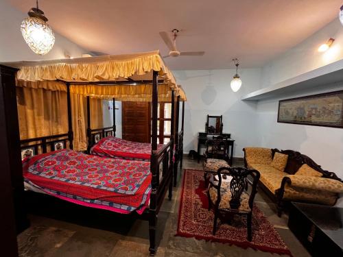a bedroom with a bed and a couch in a room at Sharad Baug homestay in Bhuj