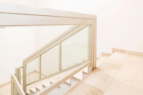 a staircase with glass railing and white walls at Hotel Sauce in Zaragoza