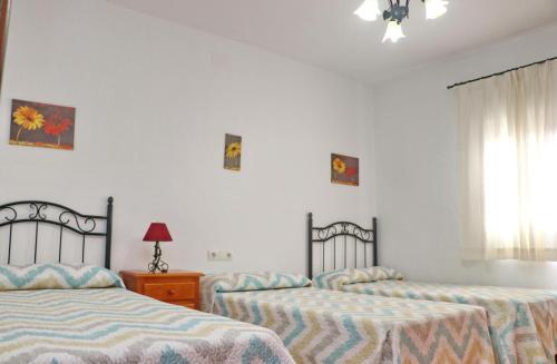 twee bedden in een kamer met witte muren bij Chalet Verde Agua in Conil de la Frontera