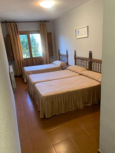 1 Schlafzimmer mit 3 Betten in einem Zimmer in der Unterkunft Hotel Restaurante Rio Cuervo in Vega del Cadorno