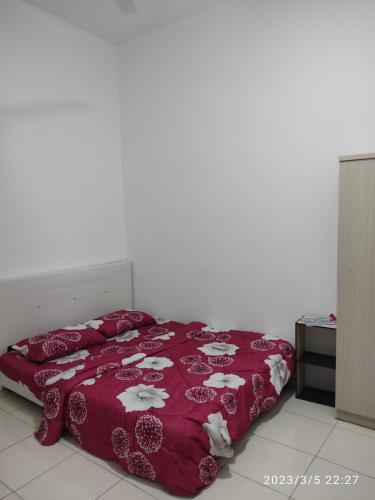um quarto com uma cama com um edredão vermelho em Homestay Changlun em Changlun