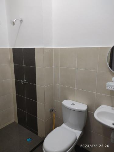 La salle de bains est pourvue de toilettes et d'un lavabo. dans l'établissement Homestay Changlun, à Changlun