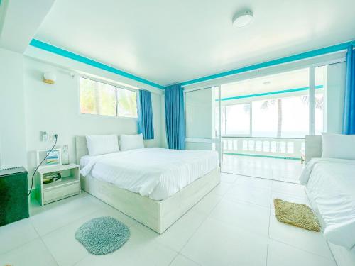 a bedroom with two beds and a large window at Paradise Resort Doc Let - All Inclusive in Doc Let