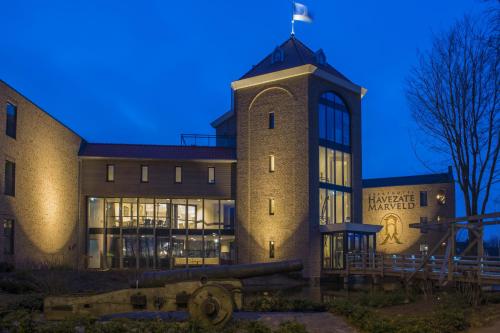 a building with a clock tower at night at Havezate Marveld in Groenlo
