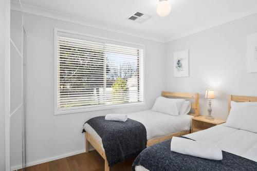 1 Schlafzimmer mit 2 Betten und einem Fenster in der Unterkunft The Scotty House - EV and pet friendly in Moss Vale