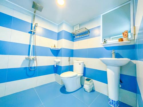 a blue and white bathroom with a toilet and a sink at Paradise Resort Doc Let - All Inclusive in Doc Let