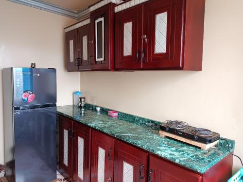 a kitchen with red cabinets and a black refrigerator at Fully furnished condo in the center of addis ababa in Addis Ababa