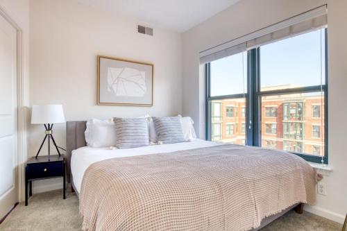 a bedroom with a bed and a large window at Logan Circle 2BR w Gym WD Pool nr bars WDC-481 in Washington, D.C.