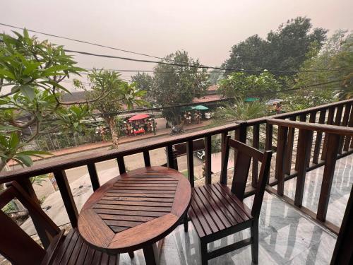 a wooden chair on a balcony with a view of a street at Chaluenxay Xiengthong Place in Luang Prabang
