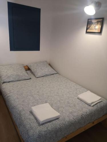 Appartement cosy au centre-ville de Toulouse في تولوز: سرير في غرفة عليها منشفتين