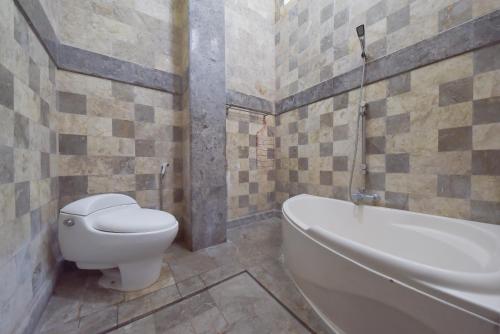 a bathroom with a toilet and a bath tub at RedDoorz Syariah near Dago Pakar 2 in Bandung