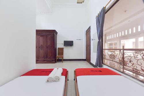 two beds in a room with a balcony at RedDoorz Syariah near Dago Pakar 2 in Bandung