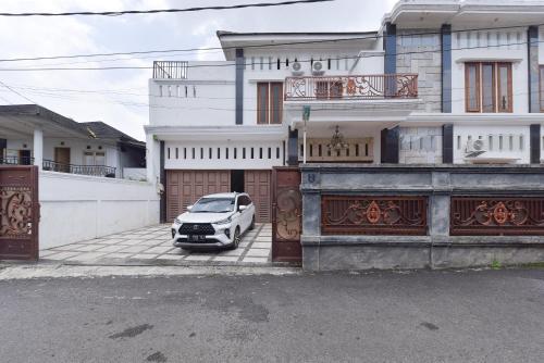 a white car parked in front of a house at RedDoorz Syariah near Dago Pakar 2 in Bandung